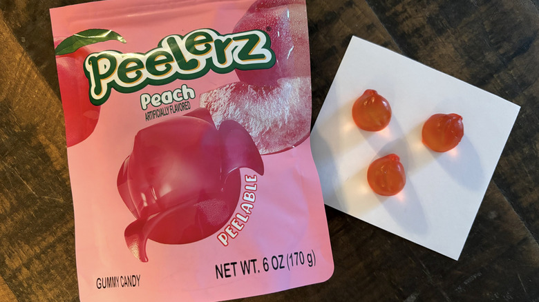 Peelerz peach flavored gummy candy in bag and paper on wooden table.