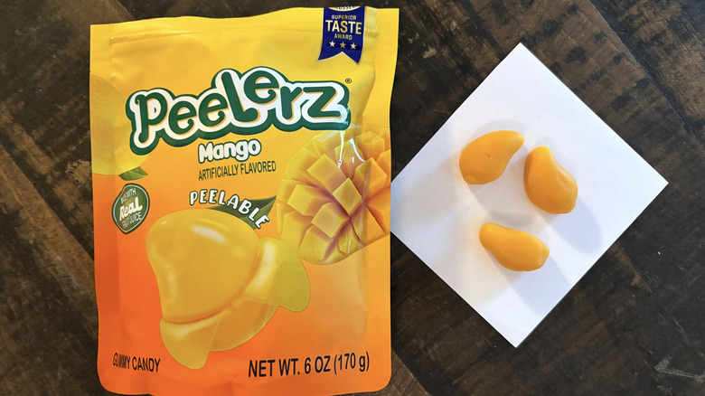 Peelerz mango flavored gummy candy in bag and paper on wooden table.