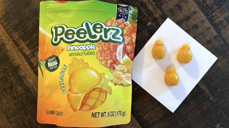 Peelerz pineapple flavored gummy candy in bag and paper on wooden table.