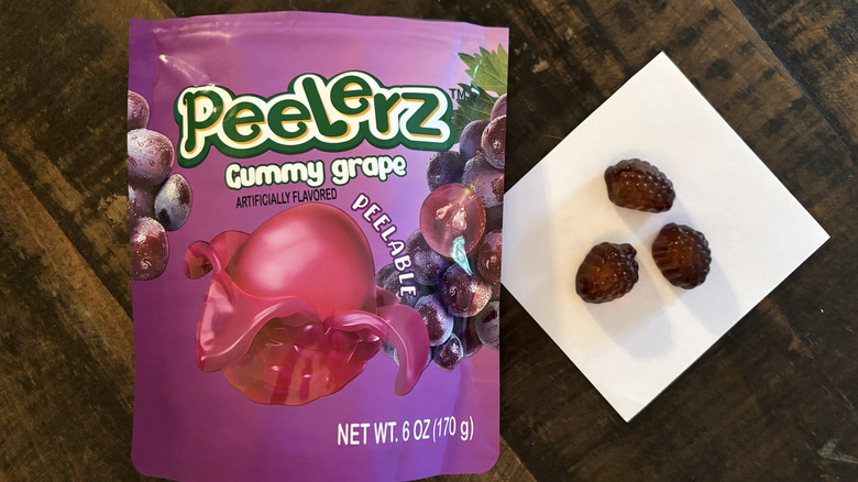 Peelerz grape flavored gummy candy in bag and paper on wooden table.