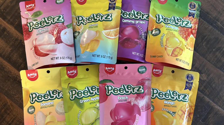 A variety of Peelerz gummy candy in bags on wooden table.