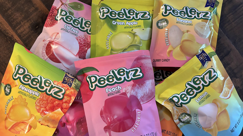 A variety of Peelerz gummy candy in bags on wooden table.