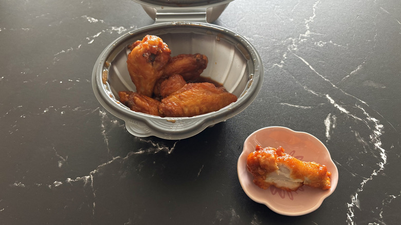 Pizza Hut Buffalo mild wing on a plate with a whole portion in a container
