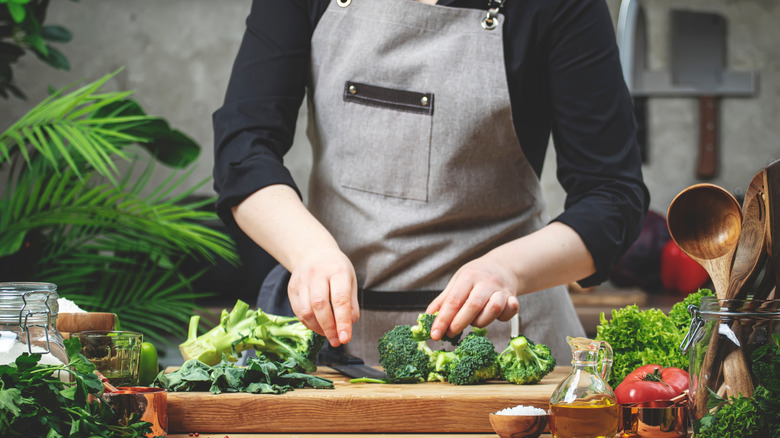 Person chopping vegetables on wooden chopping board