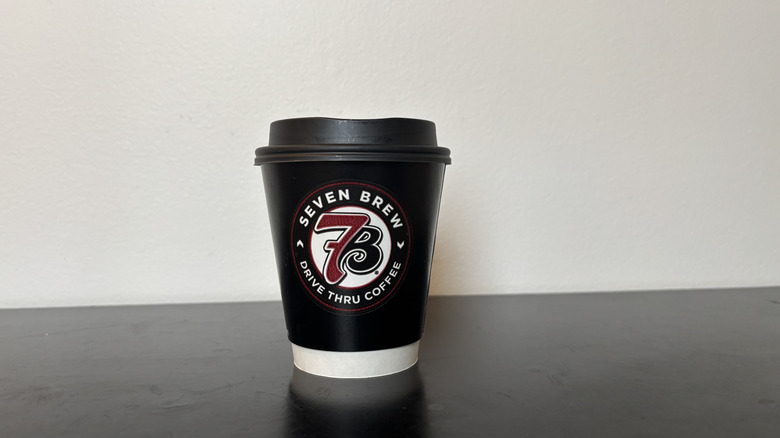 7 Brew black coffee cup on table