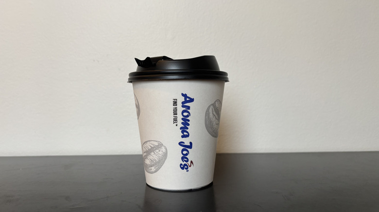 aroma joe's white coffee cup on table