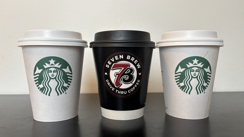 three coffee shop coffee cups on black table