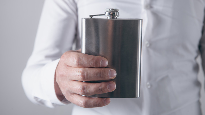 Person holding flask in hand