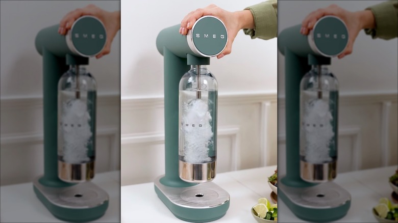 Smeg sparkling water maker carbonating water in a bottle