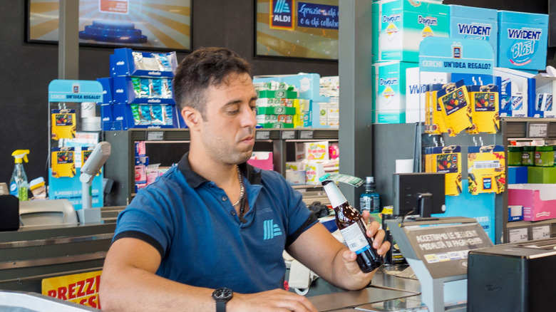 Cashier scanning groceries at an ALDI checkout counter