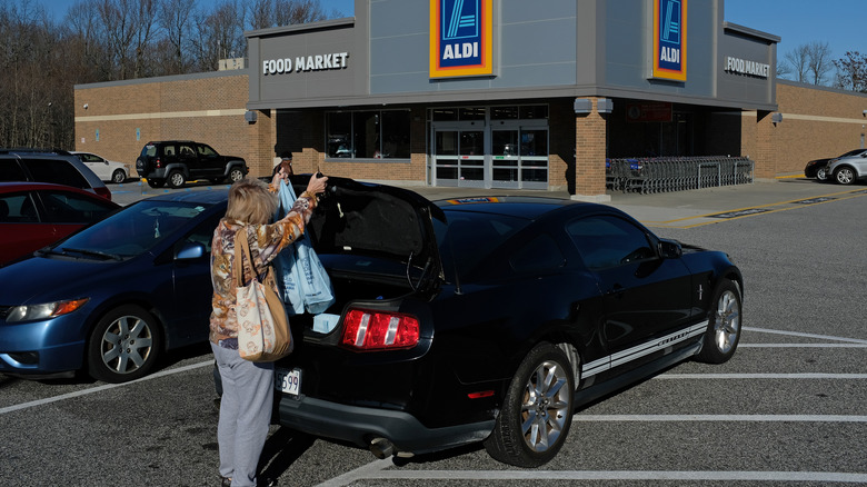 A shopper loads her car outside an Aldi store