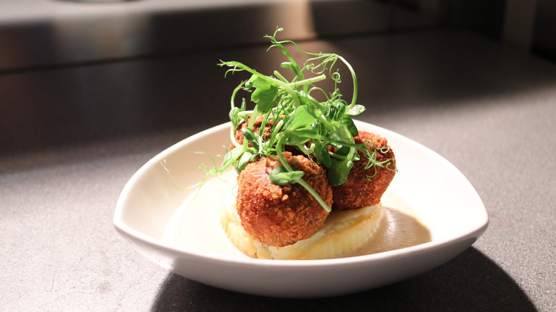 Fancy plate of haggis bon bons with green garnish