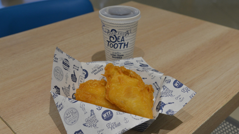 Fried fish in a paper-lined basket with a drink from Long John Silver's