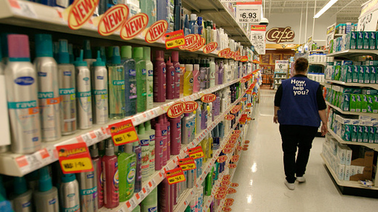 The back of a Walmart employee walking through toiletries aisle