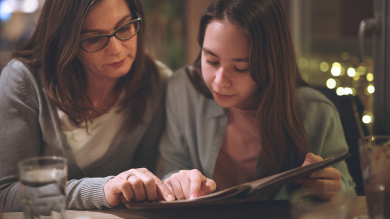 Two women sitting in a restaurant and looking at the menu
