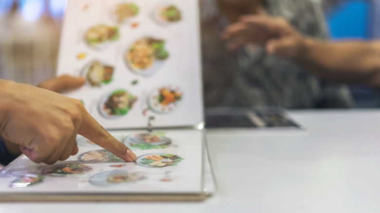 A person reading menu at table