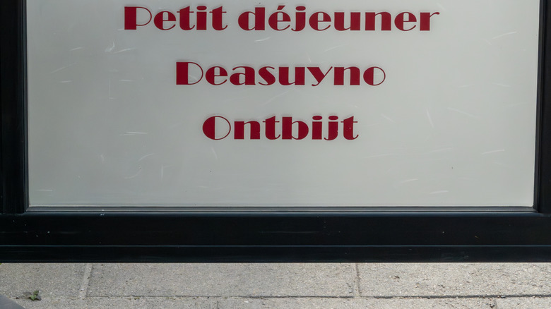 A sign in multiple languages at a Swedish cafe offers breakfast.