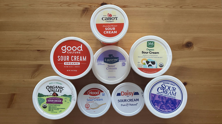 Sour cream containers on wooden table