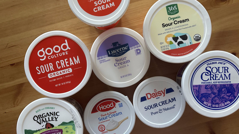 Sour cream containers on wooden table