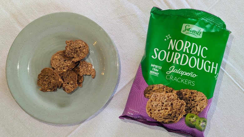 A bag of Savoritz Nordic Sourdough Jalapeño Crackers next to crackers on a blue plate