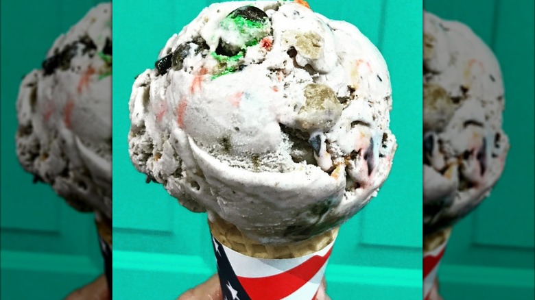 A cone with a large scoop of Cookie Jar ice cream.