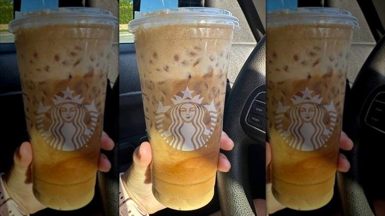 Hand holding venti sized shaken espresso drink from Starbucks