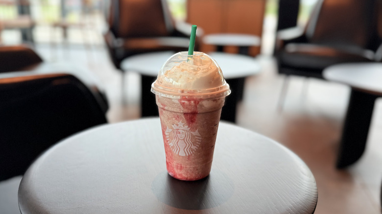 Frappula Frappuccino in a plastic cup with a straw on a table inside Starbucks