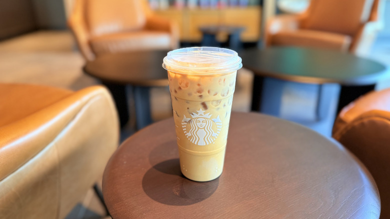 Pecan Pie drink in a plastic cup on a wooden table inside Starbucks cafe
