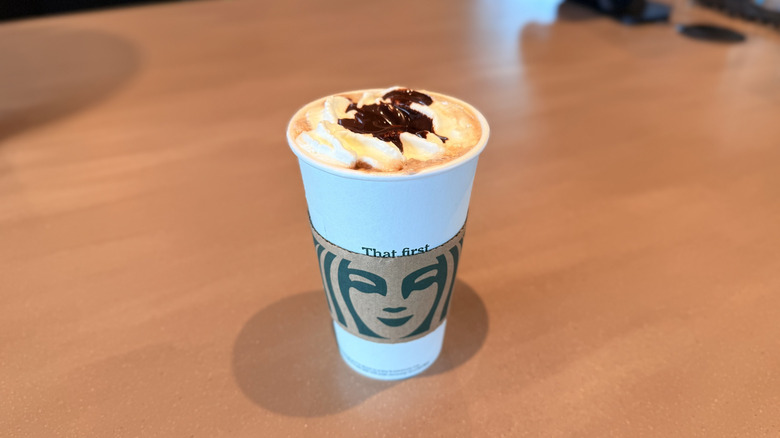 Starbucks Pumpkin Spice Hot Chocolate in a paper cup on table