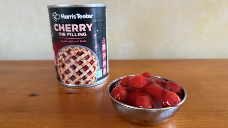 Bowl of gelatinous cherry pie filling in front of can