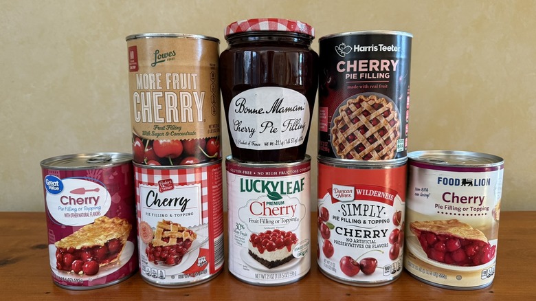 Eight cherry pie fillings stacked on wooden table