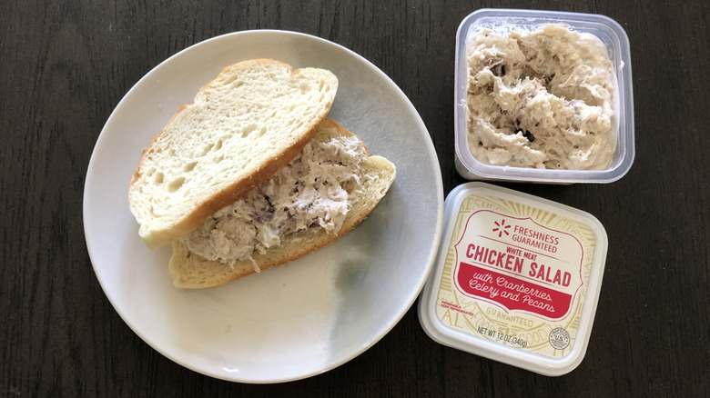 Walmart chicken salad with cranberries, celery, and pecans on a sandwich on a plate