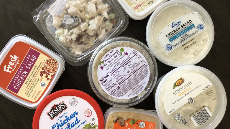 top-down view of eight different containers of store-bought chicken salads