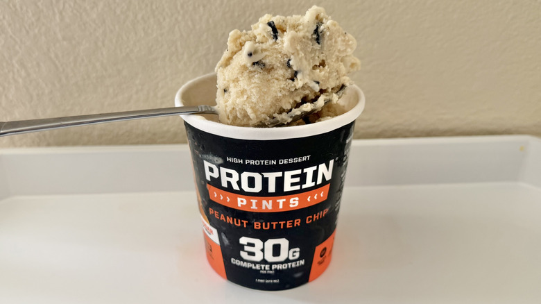 Protein Pints 30G Protein Peanut Butter Chip ice cream container with some ice cream on a spoon