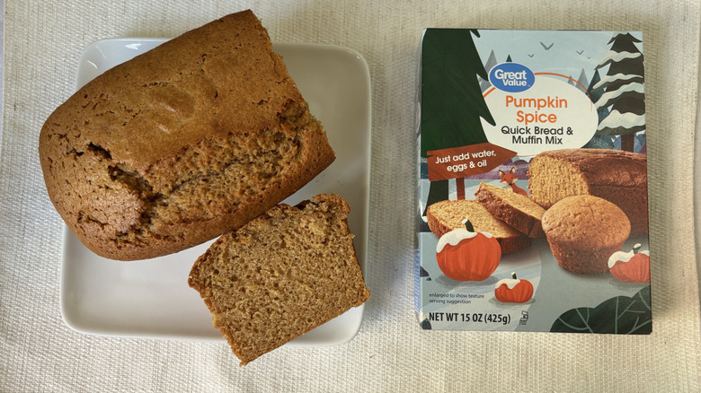 Baked loaf Great Value Pumpkin Spice Quick Bread & Muffin Mix with a slice on a plate next to box