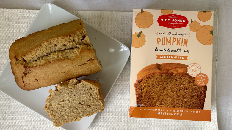 Baked, sliced loaf Miss Jones Baking Co. gluten free pumpkin bread on plate next to box