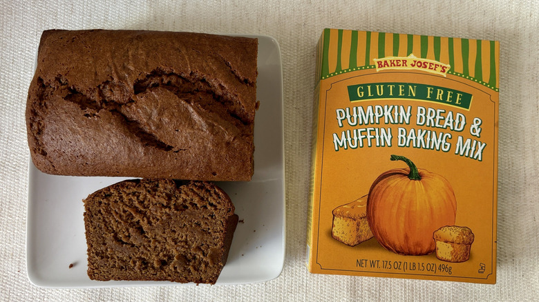 Baked loaf Trader Joe's Gluten Free Pumpkin Bread & Muffin Baking Mix with a slice on a plate next to box