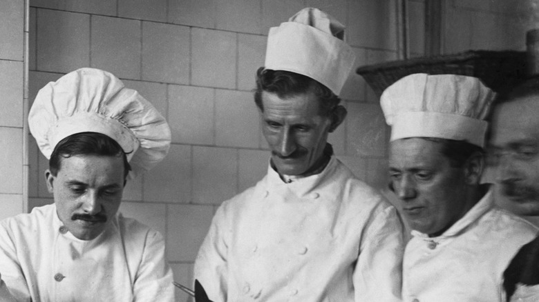 Old image of chefs preparing turtle for culinary use