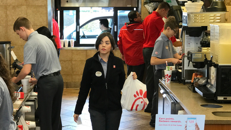 Employees in a busy Chick Fil A kitchen