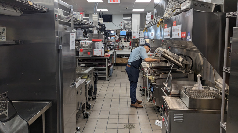 Employee preparing food in the kitchen of a Chick-fil-A fast food restaurant