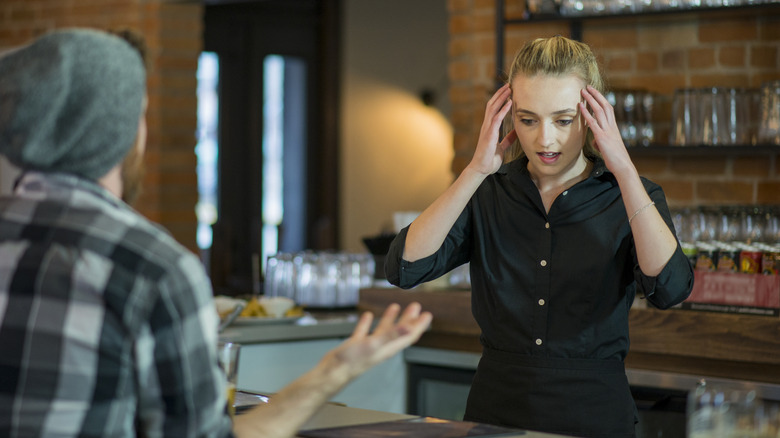 Irritated restaurant servers with hands up