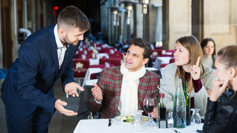 Restaurant server talking to table of customers