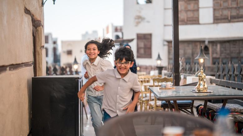 Two kids running around restaurant