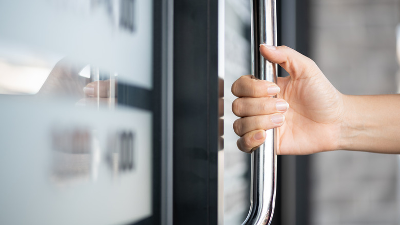 woman holding the handle of a door
