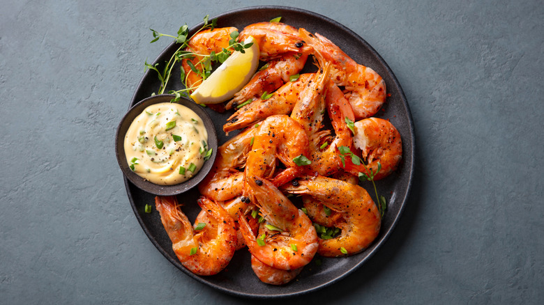 shrimp with a lemon wedge and sauce