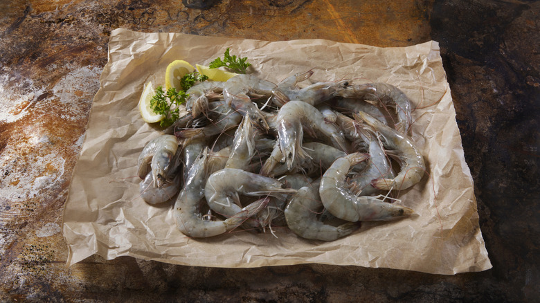 raw shrimp on parchment with lemon