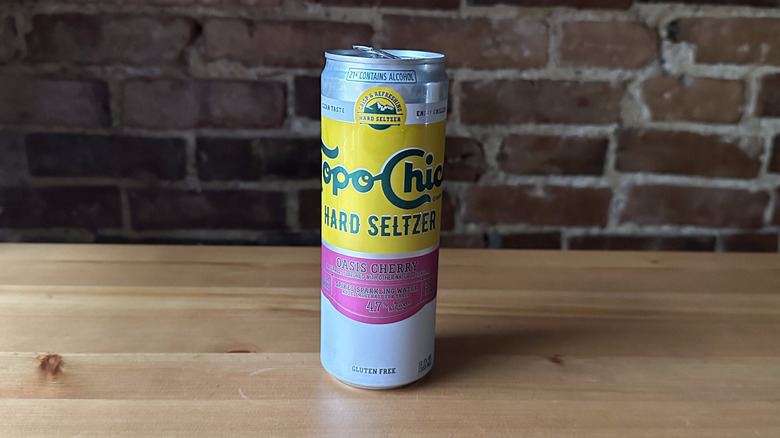 Topo Chico Oasis Cherry Seltzer on wooden table