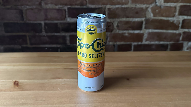 Topo Chico Tropical Mango Seltzer on wooden table