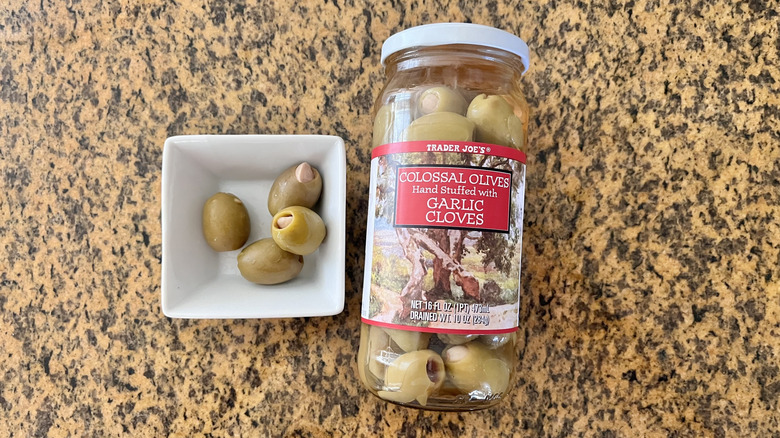 Jar of Colossal Olives Stuffed with Garlic Cloves with olives in a small dish