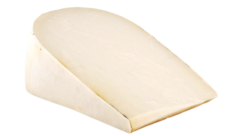 Wedge of young goat gouda cheese